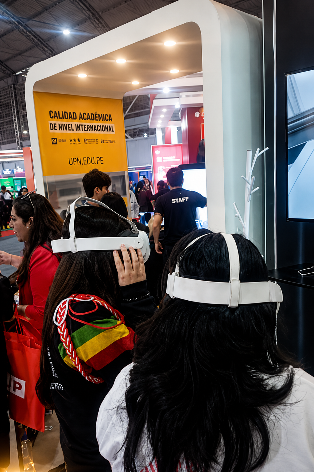 Postulantes con visores VR en stand universitario